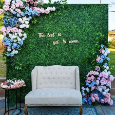 a white chair sitting in front of a green wall with flowers on it and the words, there best is yet to come