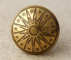 an antique brass door knob with decorative designs on the outside and inside, sitting on a white surface