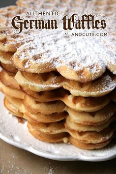 a stack of waffles covered in powdered sugar on top of a white plate