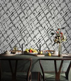 a dining room table with plates and bowls of food on it next to a wallpaper