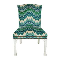 an upholstered chair with a green and white pattern on the back, against a white background