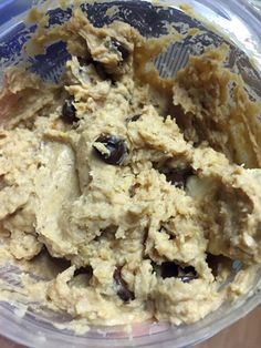 a bowl filled with dough and raisins on top of a table