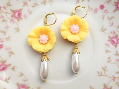 "These beautiful hibiscus earrings were created with brass lace settings adorned with yellow and pink hibiscus flowers and Vintage teardrop glass pearls. These floral earrings hang beautifully from the ear and measure 2 1/2 inches in length and measure 3/4 inches in width at widest point. These earrings make the \"perfect gift\" for your mom, sister, daughter, friend, girlfriend, wife or bridesmaids....She will truly love these and treasure them for many years to come. ~All of my listings are ha Yellow Flower-shaped Party Earrings, Elegant Yellow Dangle Flower Earrings, Elegant Yellow Dangle Clip-on Earrings, Elegant Yellow Flower Earrings For Wedding, Elegant Yellow Flower Shaped Earrings, Elegant Yellow Flower-shaped Earrings, Yellow Flower Earrings For Wedding, Yellow Flower Drop Earrings For Wedding, Handmade Yellow Flower Earrings For Wedding