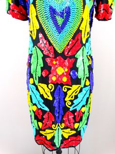 "A stunning vintage dress! Beautifully embellished with bright and bold colorful sequins and black beading in a retro design on both the front and the back. It's in perfect condition! Measurements: Bust - 36\" Waist - 33\" Hips - 38\" Length - 37\" ❖ This dress comes from a pet-free and smoke-free home. ❖ If you would like more info or have any questions, please don't hesitate to ask!" Embellished Dress For Costume Party During Party Season, Summer Sequin Embellished Dress For Costume Party, Embellished Sequin Dress For Costume Party And Holiday, Summer Festival Embellished Sequin Dress, Summer Festive Embellished Sequin Dress, Festive Embellished Sequin Summer Dress, Sequined Dresses For Festival And Night Out, Embellished Multicolor Sequin Dress For Night Out, Embellished Multicolor Sequin Summer Dress