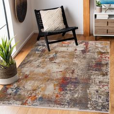 a chair and rug in a room with wooden floors, white walls and wood flooring