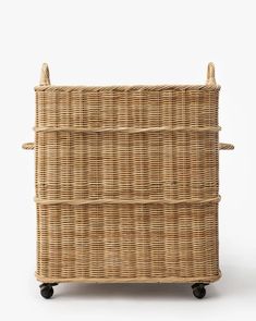 a wicker basket with wheels and handles on the bottom, against a white background