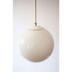 a white light hanging from a ceiling fixture with a wooden stick sticking out of it