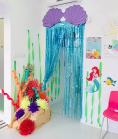 a room decorated with mermaid decorations and streamers