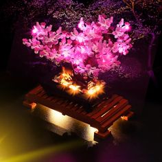 a purple flower arrangement is lit up on a bench