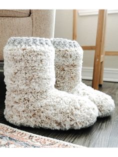 a pair of boots sitting on top of a wooden floor next to a chair and rug