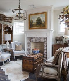 a living room filled with furniture and a fire place in front of a painting on the wall