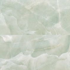 two white marble tiles are shown in close up, one is light green and the other is pale blue