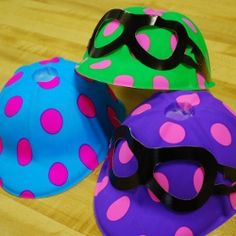 three hats and goggles sitting on top of a wooden table