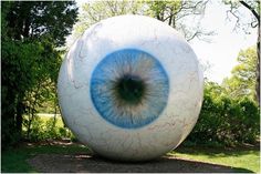 an eyeball with blue and white paint on it in the middle of a park