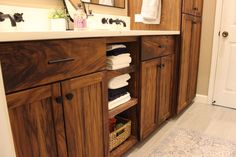 a bathroom with wooden cabinets and white towels