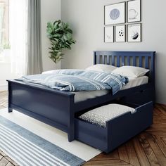 a bed with two drawers underneath it in a room next to a window and rug