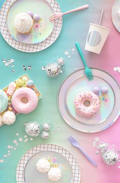 a table topped with plates and donuts covered in frosted sprinkles