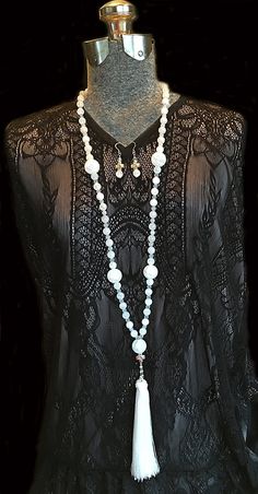 Make a dramatic statement in this stunning long, white frosted glass beaded tassel necklace. The opera length necklace features small silver crosses depicting the Virgin Mary tenderly cradling the baby Jesus. The image appears on both sides of the cross. The six inch tassel is luxurious and suspended from a pearl and silver loop of rosary chain. Beautiful in daylight or candlelight this lovely necklace would be stunning against velvet for a winter bride. The matching earrings also feature fro... White Single Strand Spiritual Necklace, Spiritual Single Strand White Necklace, White Beaded Cross Jewelry, White Single Strand Long Necklace As Gift, White Spiritual Beaded Necklace With Faceted Beads, Spiritual White Beaded Necklace With Faceted Beads, White Spiritual Beaded Jewelry, White Faceted Beads Dangle Jewelry, Spiritual White Beaded Jewelry