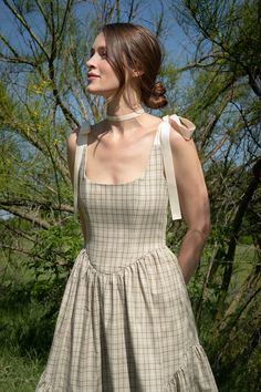 Ready to ship A truly special dress. Classic sage plaid with cream ribbon ties make this warm weather Mirabelle a timeless heirloom piece that will always be in style. With a full corseted bodice, and sweeping ruffle hem -- the Mirabelle Dress is dramatic, romantic beauty at its best. DETAILS: Pockets, of course! Lined bodice with boning, ribbon-tie straps, side zip and ruffle hem. FIT: Structured bodice with "held in" fit, easy fit across hips. Full skirt hits at mid-calf, fits most petites wit Prarie Core Fashion, Ribbon Strap Dress, Lenin Dress, Dramatic Romantic, Heirloom Dresses, Special Dress, Special Dresses, Smallville, 가을 패션