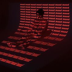 a man standing in front of a wall with words projected on it