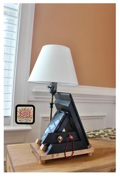 a lamp sitting on top of a wooden table next to a small box with an electronic device in it