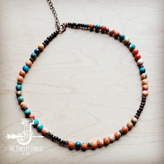 Bring boho vibes anywhere with this colorful beaded necklace! This handmade beaded necklace features a combination of multi-colored beads, wood beads, and copper beads. Worn at the collar bone, this colorful beaded necklace is great for layering with long turquoise necklaces or worn alone as a statement piece. An extender chain and lobster claw clasp make this boho beaded necklace easy to wear. Although this handmade beaded necklace will resemble the photo, no two pieces of our handmade beaded j Rustic Adjustable Beaded Necklace, Earthy Multicolor Beaded Necklaces With Natural Stones, Earthy Multicolor Gemstone Beaded Necklaces, Bohemian Brown Beaded Choker, Bohemian Heishi Beads Choker For Festivals, Earthy Turquoise Beaded Necklaces With Round Beads, Earthy Multicolor Beaded Necklaces For Jewelry Making, Bohemian Heishi Beads Choker, Bohemian Turquoise Necklace With Colorful Heishi Beads