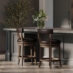 two wooden stools sitting in front of a counter