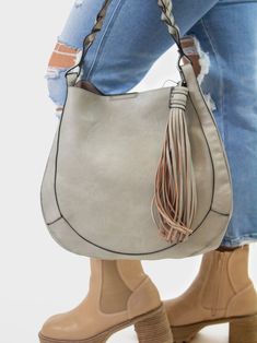 Treat yourself to the bag of your dreams with this gorgeous hobo bag that packs a punch. This shoulder bag, complete with vegan leather and an adjustable shoulder strap, arrives with a cute tassel for added flair! Go ahead and surprise yourself with this one. Braided top handle hobo Large side tassel Top snap closure Adjustable shoulder strap Inner bag with top zipper closure, inner zip pocket and two pouches Vegan leather Dimensions: 13"L x 13"H x 5.5"D, drop 7.5" Trendy Hobo Bag For On-the-go, Trendy Everyday Bags With Tassels, Trendy Everyday Shoulder Bag With Tassels, Trendy Hobo Bag Tote With Tassels, Trendy Tassel Hobo Shoulder Bag, Everyday Bags With Tassels, Crossbody Hobo Bag With Tassels, Daily Use Crossbody Hobo Bag With Tassels, Trendy Hobo Bag With Fringe For Everyday Use