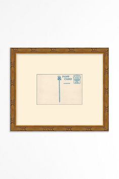 a framed drawing of a blue toothbrush on a white wall next to a brown frame