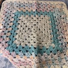 a crocheted blanket is laying on the floor