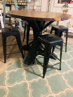 a table with four chairs around it in a room filled with books and other items