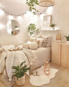 a bedroom with white walls and wooden flooring, potted plants on the bed