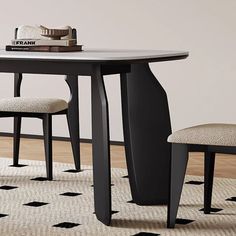 a black table with two chairs and a white rug