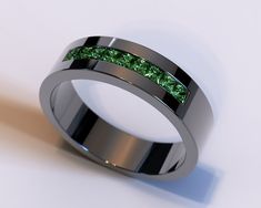 a wedding band with green moss inlays is shown on a white surface,