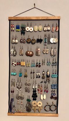 a wall mounted jewelry rack with earrings on it