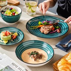 a person is cutting into some food on a table with other plates and utensils