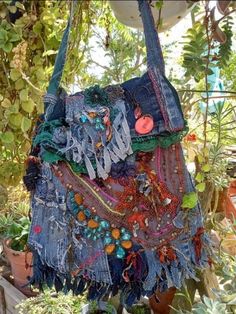 a purse is hanging from a tree in a garden filled with plants and potted plants