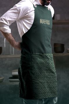 a man wearing an apron with his hands on his hips