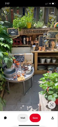 an outdoor market with lots of plants and food on the table in front of it