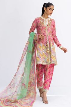 This short, aurora pink angarkha is the embodiment of a classy yet charming festive look. It is rendered with a thoughtful arrangement of zardoze and gota work on a floral-printed khaddi silk, featuring a chatapatti border. A multi-coloured dupatta with gota finishing and a printed shalwar add the final touches to this Pink Traditional Wear With Gota Work For Designer Occasions, Pink Dola Silk Sets With Gota Work, Festive Silk Kurta With Naqshi Detail, Festive Silk Kurta With Naqshi, Festive Silk Traditional Wear With Naqshi, Festive Chinon Dupatta With Naqshi, Eid Dola Silk Salwar Kameez With Naqshi, Festive Naqshi Traditional Dola Silk Wear, Festive Naqshi Dupatta In Chinon