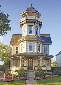 a large house with a tower on the top and stairs leading up to it's second floor