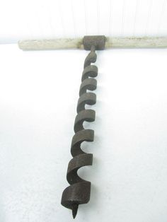 a metal object hanging on the side of a white wall next to a baseball bat