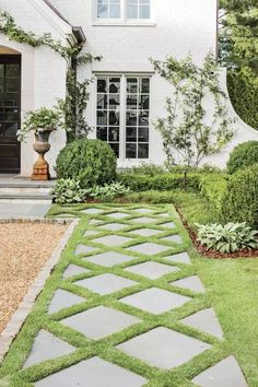 a white house with green grass in the front yard and walkway leading up to it