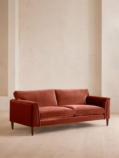 an orange couch sitting on top of a hard wood floor