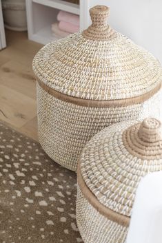 two woven baskets sitting on top of a rug