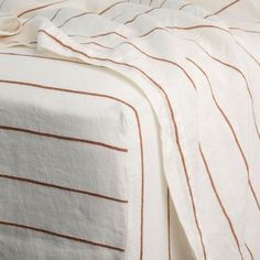 an image of a bed with white and brown sheets