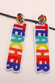 two colorful beaded earrings are hanging from a string on a white surface, one is decorated with multicolored beads and the other has a rainbow bus