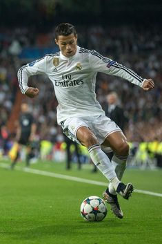 a man kicking a soccer ball on top of a field