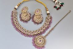 * Necklace Length - 14 -16 inches adjustable * Necklace Width - 1.2 Inch * Earrings Length - 1.7 inches * Earrings Width -0.4 inches **Simi Lavender Polki Choker Necklace** Elevate your elegance with the Simi Lavender Polki Choker Necklace, a masterpiece of Indian jewelry craftsmanship. This exquisite piece blends traditional charm with contemporary sophistication, making it a standout accessory for any occasion. **Design and Craftsmanship. - **Lavender Hues Adorned with delicate lavender-colore Traditional Adjustable Purple Jewelry, Round Kundan Necklace Gift, Round Kundan Necklace With Jewels As Gift, Adjustable Pink Jeweled Jewelry, Purple Party Jewelry With Adjustable Chain, Adjustable Round Kundan Necklace As Gift, Adjustable Round Bridal Necklace, Adjustable Round Bridal Necklace Gift, Adjustable Hand-set Necklace As Gift