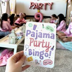 a person holding up a sign that says pajama party bingo